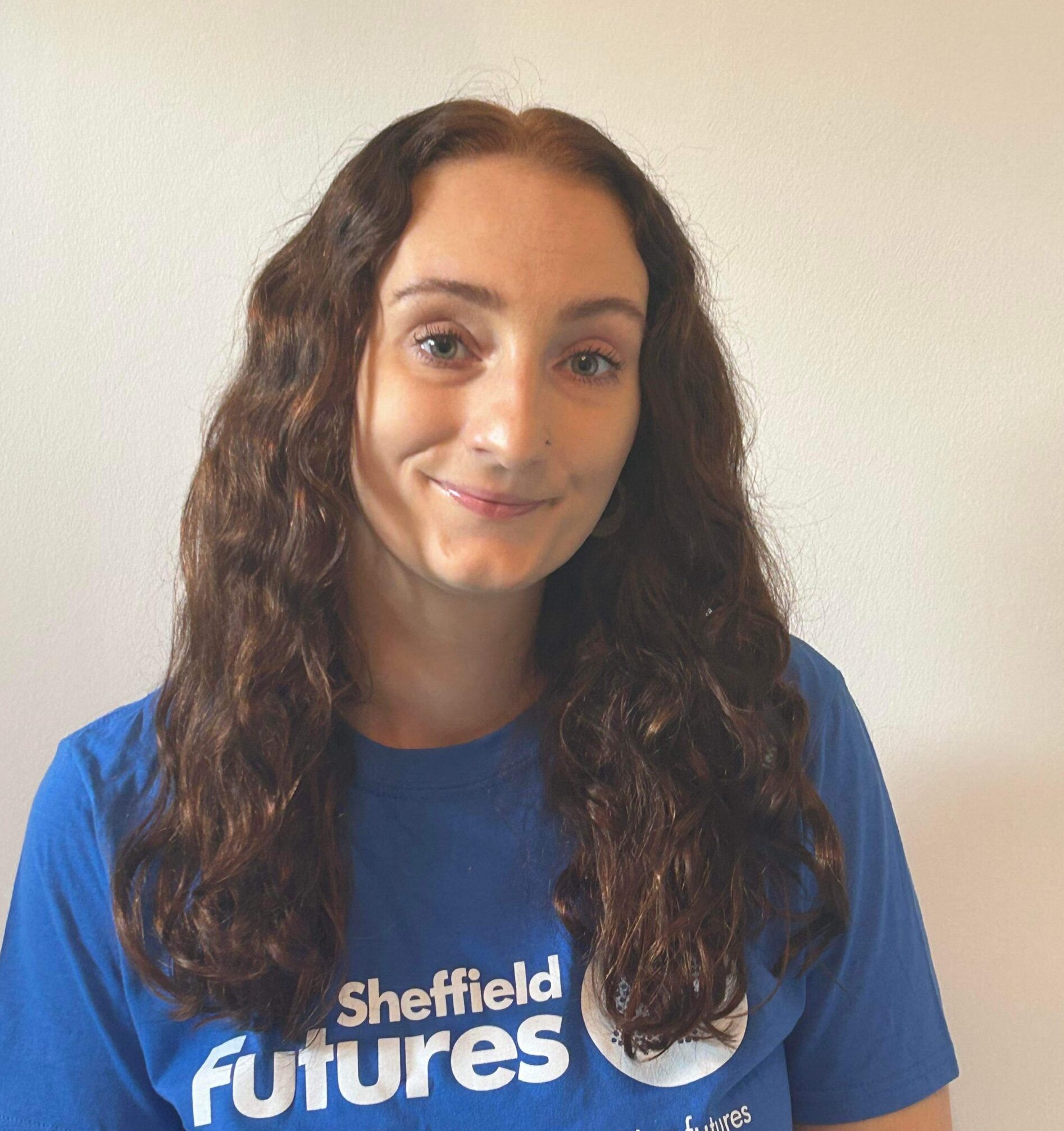 Kitty Hood, a social prescriber, smiles for the camera wearing a Sheffield Futures t-shirt