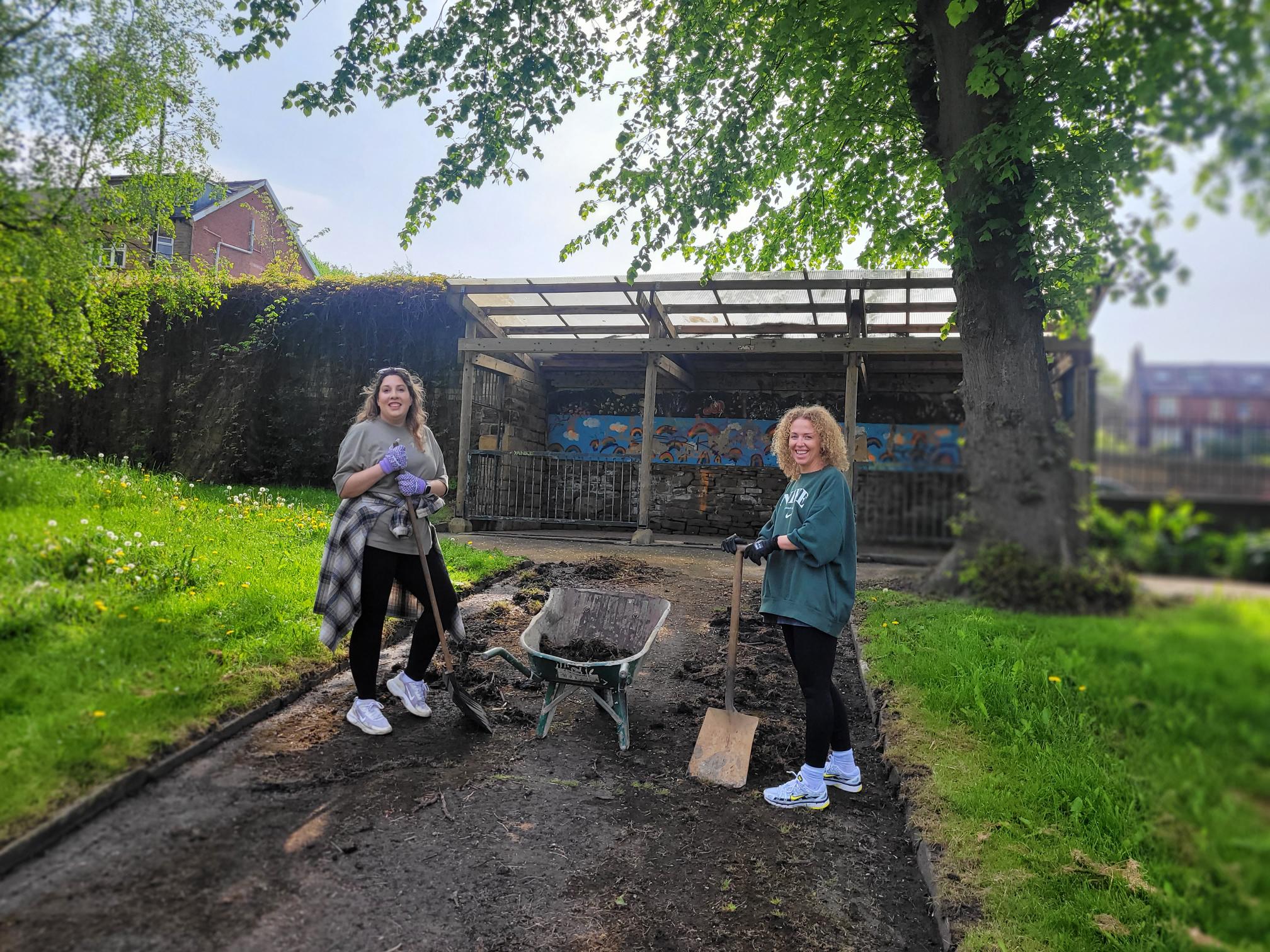 two SF staff members pause for a photo in the middle of volunteering at Abbeyfield Park